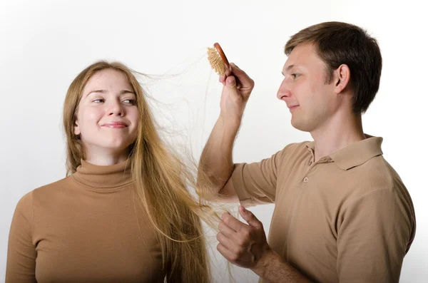 माणूस त्याच्या गर्लफ्रेंडचे केस कॉम्बिंग करीत आहे — स्टॉक फोटो, इमेज