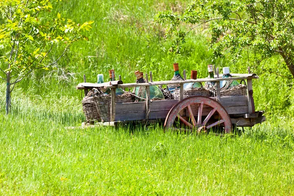 Velho vagão rústico com garrafas de vinho — Fotografia de Stock