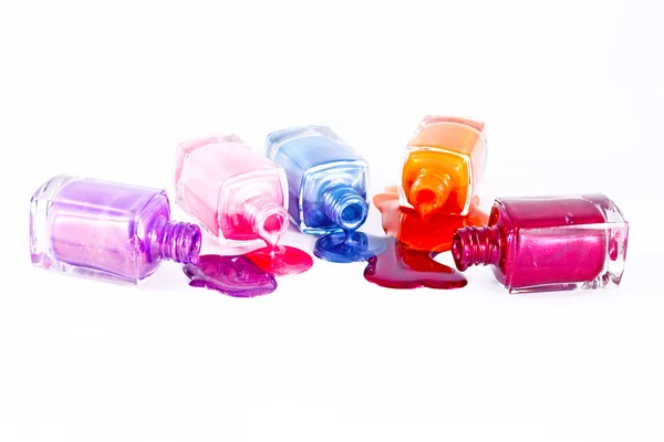 Пляшки з розлитим лаком для нігтів на білому тлі — стокове фото