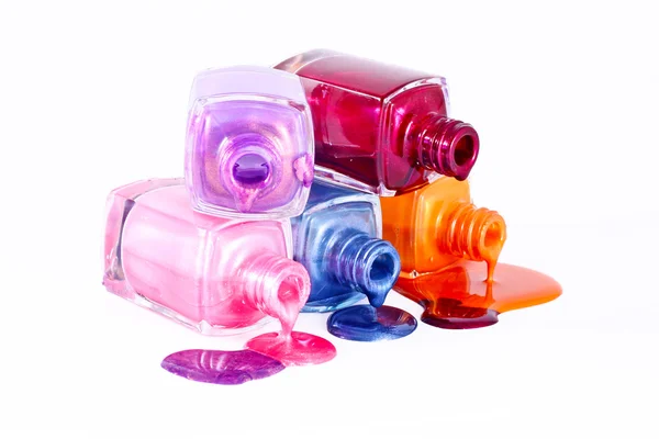 Бутылки с пролитым лаком для ногтей на белом фоне — стоковое фото