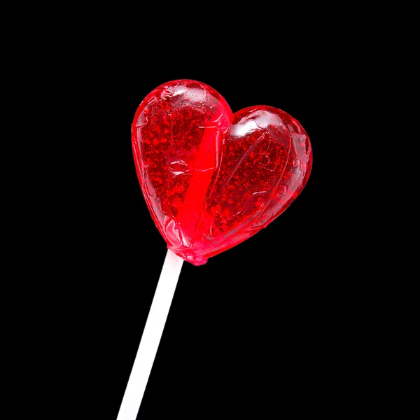 Vermelho em forma de coração pirulito tiro sobre fundo preto — Fotografia de Stock