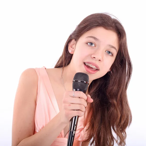Fin tenåringsjente med mikrofon, som synger – stockfoto