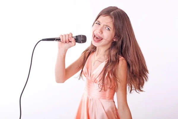 漂亮的年轻女孩用麦克风唱歌 — 图库照片