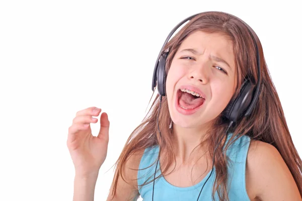 Милая девочка-подросток слушает музыку в наушниках — стоковое фото
