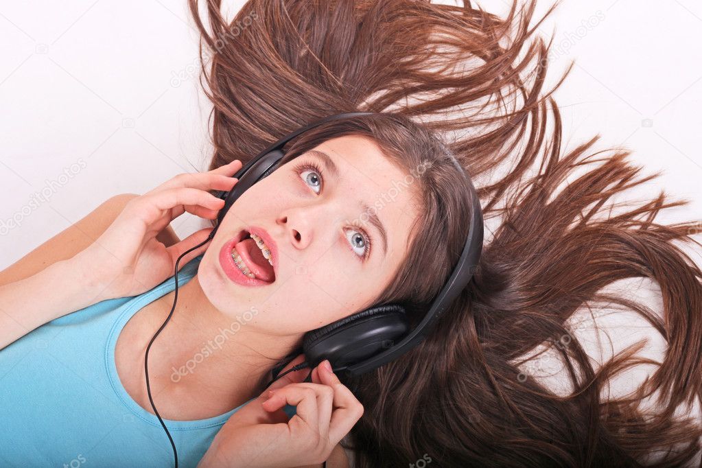 Nice teen girl listening to music with headphones