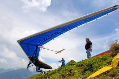 SANTS, SWITZERLAND - May 27: Competitor Ievgen Lysenko from Ukraine of the Swiss Masters hang gliding competitions takes part on May 27, 2012 in Sants, Switzerland clipart