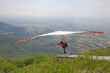 GEMONA, ITALY- JULY 2012: Artem Chervonenko competes in the Italian Open-2012 hang gliding competitions at Gemona on July 17, 2012 near Gemona, Italy clipart