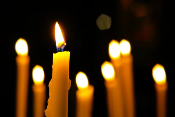 Close-up van de kaarsen snijden door de duisternis. — Stockfoto