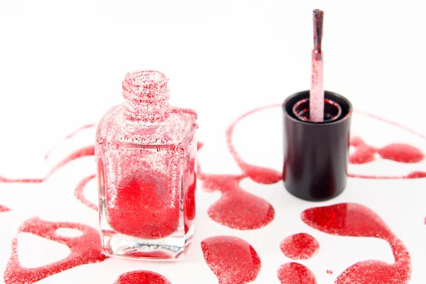 Red nail polish bottle with splatters isolated on white background — Stock Photo, Image