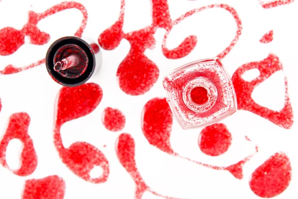 Punainen kynsilakka pullo roiskeet eristetty valkoisella taustalla — kuvapankkivalokuva