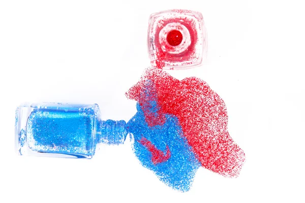 Красный и синий мерцающий лак для ногтей на белом фоне Красный и синий мерцающий лак для ногтей на белом фоне — стоковое фото