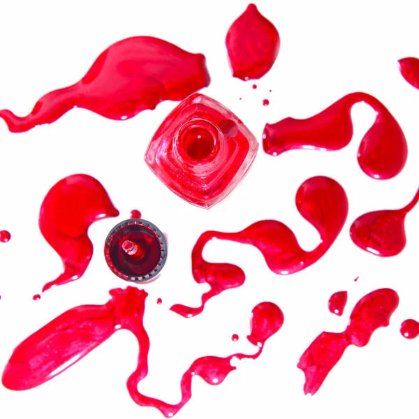 Frasco de esmalte vermelho com salpicos isolados sobre fundo branco — Fotografia de Stock