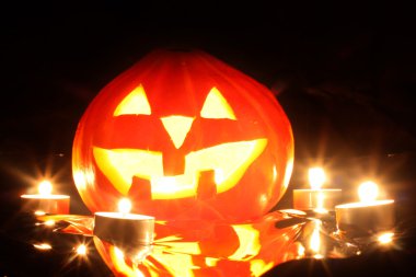 Halloween pumpkin jack-o-lantern candle lit, isolated on black background clipart