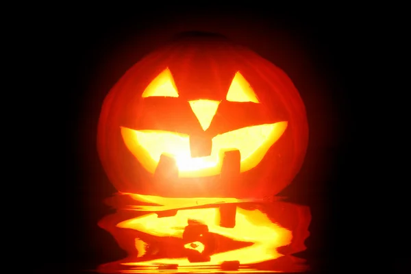 Halloween pumpkin jack-o-lantern candle lit, isolated on black background — Stock Photo, Image