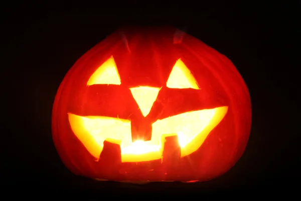 Halloween pumpkin jack-o-lantern candle lit, isolated on black background — Stock Photo, Image