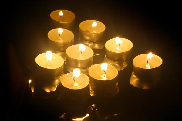 Vista de cerca de las velas que atraviesan la oscuridad Imagen de stock