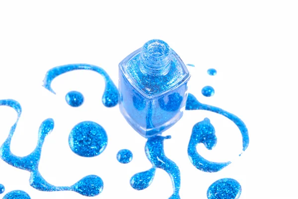 白い背景に独立したスプラッター付きブルーネイルポリッシュボトル — ストック写真