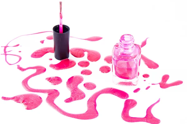 Botella de esmalte de uñas rosa con salpicaduras aisladas sobre fondo blanco —  Fotos de Stock
