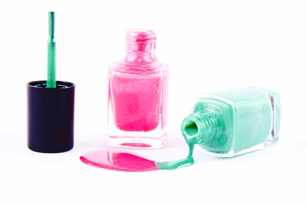 Закрыть Разлитый цветной лак для ногтей - розовый и светло-зеленый — стоковое фото