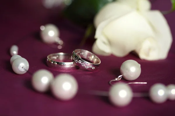Wedding rings on purple pillow — Stock Photo, Image