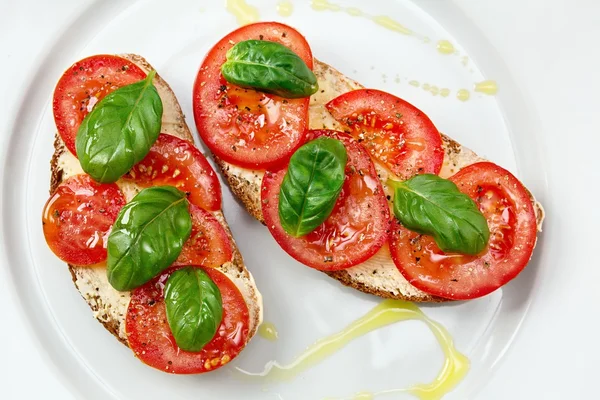 Delicious bread with tomato and basil — Stock Photo, Image