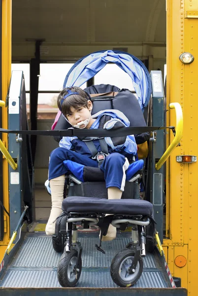 Funktionshindrade liten pojke på skolbussen rullstolslyft — Stockfoto