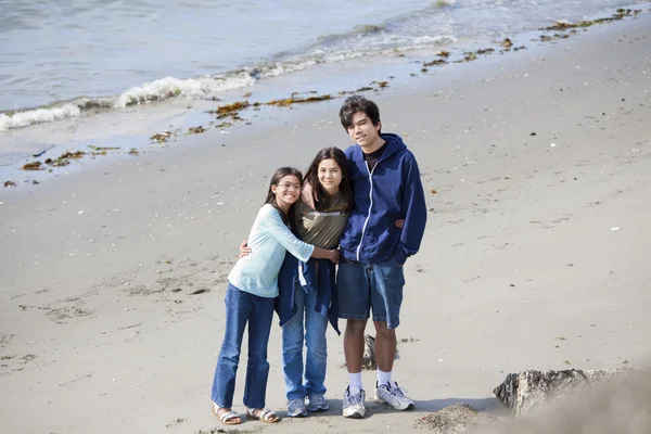 Trois frères et sœurs ensemble sur la plage — Photo