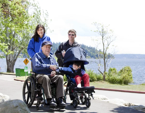 Engelli kıdemli ve açık havada yürüyen çocuk ile aile — Stok fotoğraf