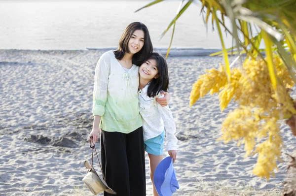 Two sisters standing on the beach — Stock Photo, Image
