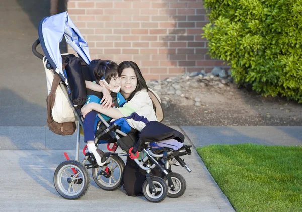 Niepełnosprawnych chłopiec w wózku i jego siostra — Zdjęcie stockowe