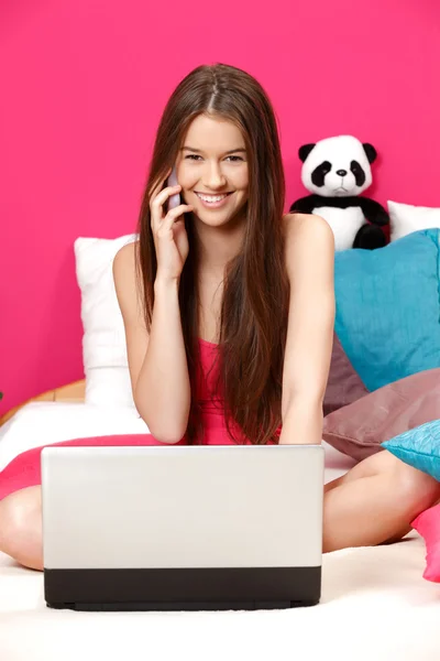 Cute girl smiling and making a call in her pink room — Stock Photo, Image