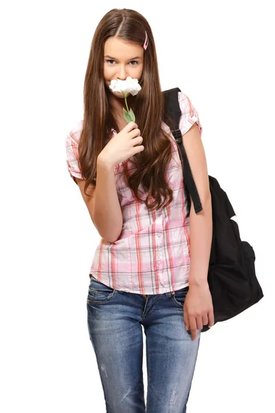 Estudante bonito cheira uma flor — Fotografia de Stock