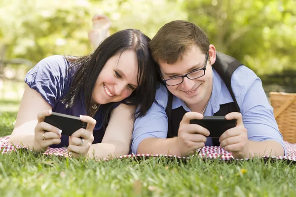 Молода пара в парку Texting разом — стокове фото