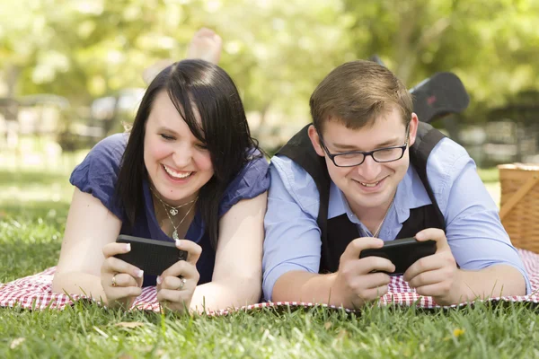 Mladý pár v parku SMS dohromady — Stock fotografie