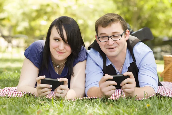 在公园发短信在一起的年轻夫妇 — 图库照片