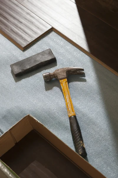 Hammer und Block mit neuem Laminatboden — Stockfoto