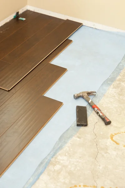 Martello e blocco con nuovo pavimento in laminato — Foto Stock