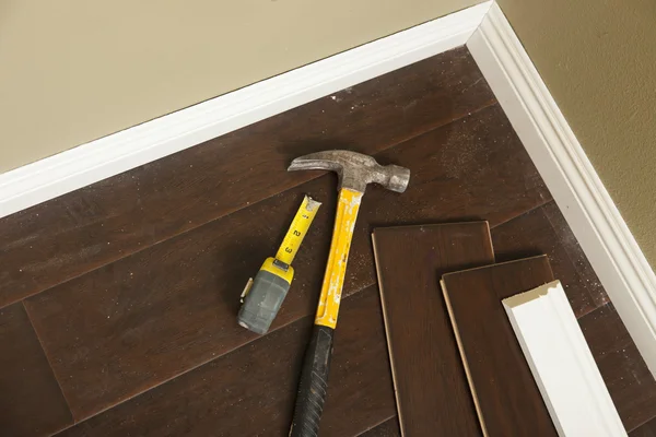 Push bezem op een geïnstalleerde laminaatvloer en baseboard — Stockfoto