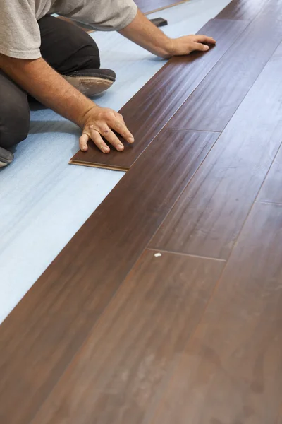 Muž instalace nové laminátové dřevěné podlahy — Stock fotografie