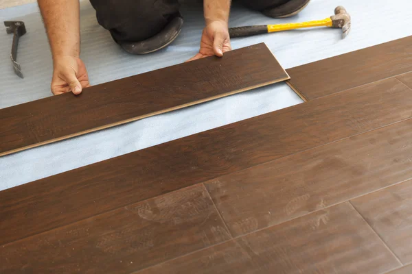 Homme Installation de nouveaux planchers de bois stratifié — Photo