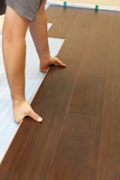 Uomo Installazione di nuovi pavimenti in legno laminato — Foto Stock