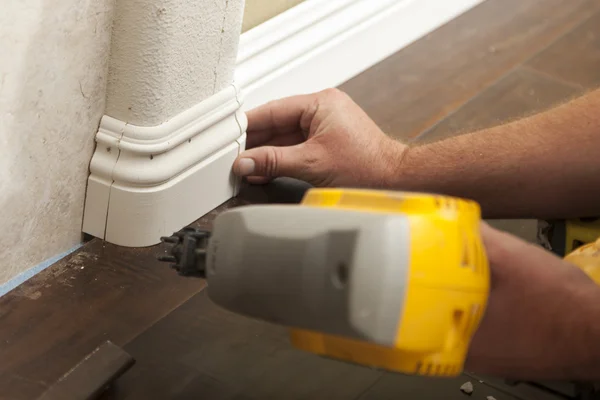 Nailing New Baseboard with Bull Nose Corners and New Laminate Fl — Stock Photo, Image