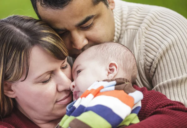 Felice razza mista genitori abbracciare il loro bambino figlio — Foto Stock
