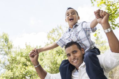 Hispanic Father and Son Having Fun in the Park clipart