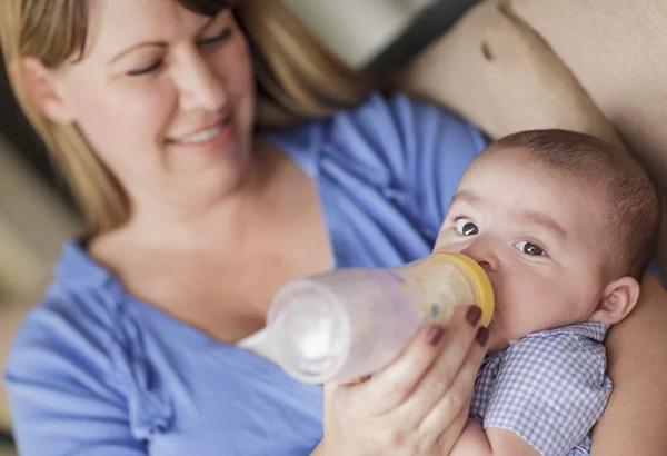 Felice madre bottiglia nutrire suo figlio — Foto Stock