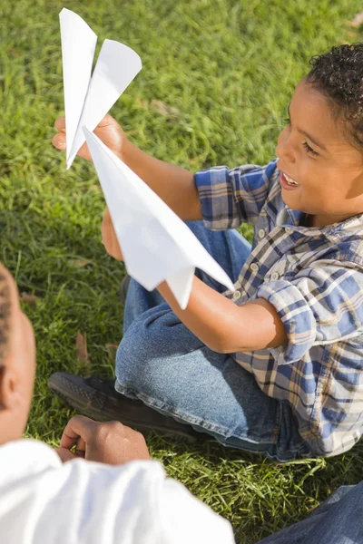 Змішаної раси батько і син грати з паперових літачків — стокове фото