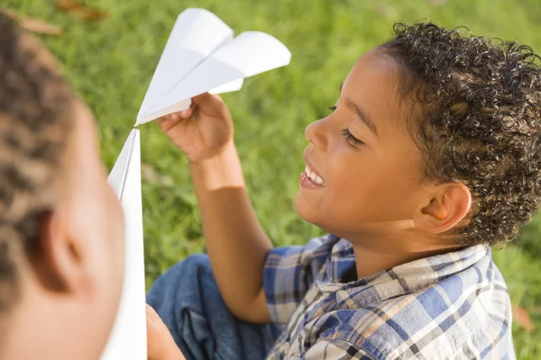 Gemengd ras vader en zoon spelen met papier vliegtuigen — Stockfoto