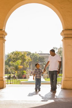 Mixed Race Father and Son Walking in the Park clipart