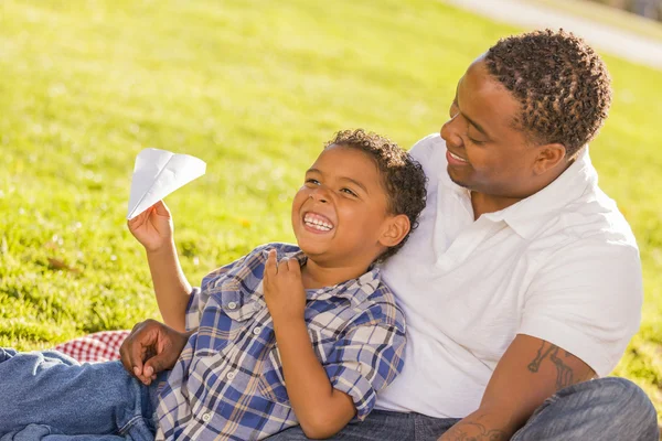 Mieszanej rasy ojciec i syn gry z samolotami papieru — Zdjęcie stockowe