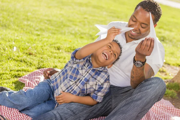 Gemengd ras vader en zoon spelen met papier vliegtuigen — Stockfoto